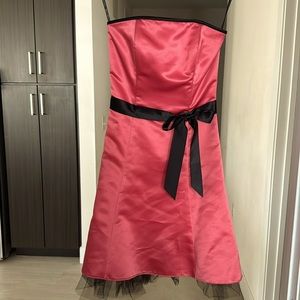 Coral colored strapless semi formal dress, black waist ribbon with bow